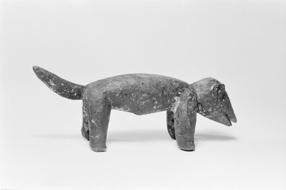 Nkita Agwu, the male dog of Agwụ Nsi, the Igbo deity of healing and divination. Acquired in 1916 from the Echie community in present-day Rivers State by the Pitt Rivers Museum. Nkita Agwu is a spiritual guardian dog linked to Agwụ, protecting dibia (healers) from evil. Igbo healers value dogs for their heightened spiritual senses, particularly their eyes, which detect malevolent forces, and dogs are often sacrificed during healer initiation rites.