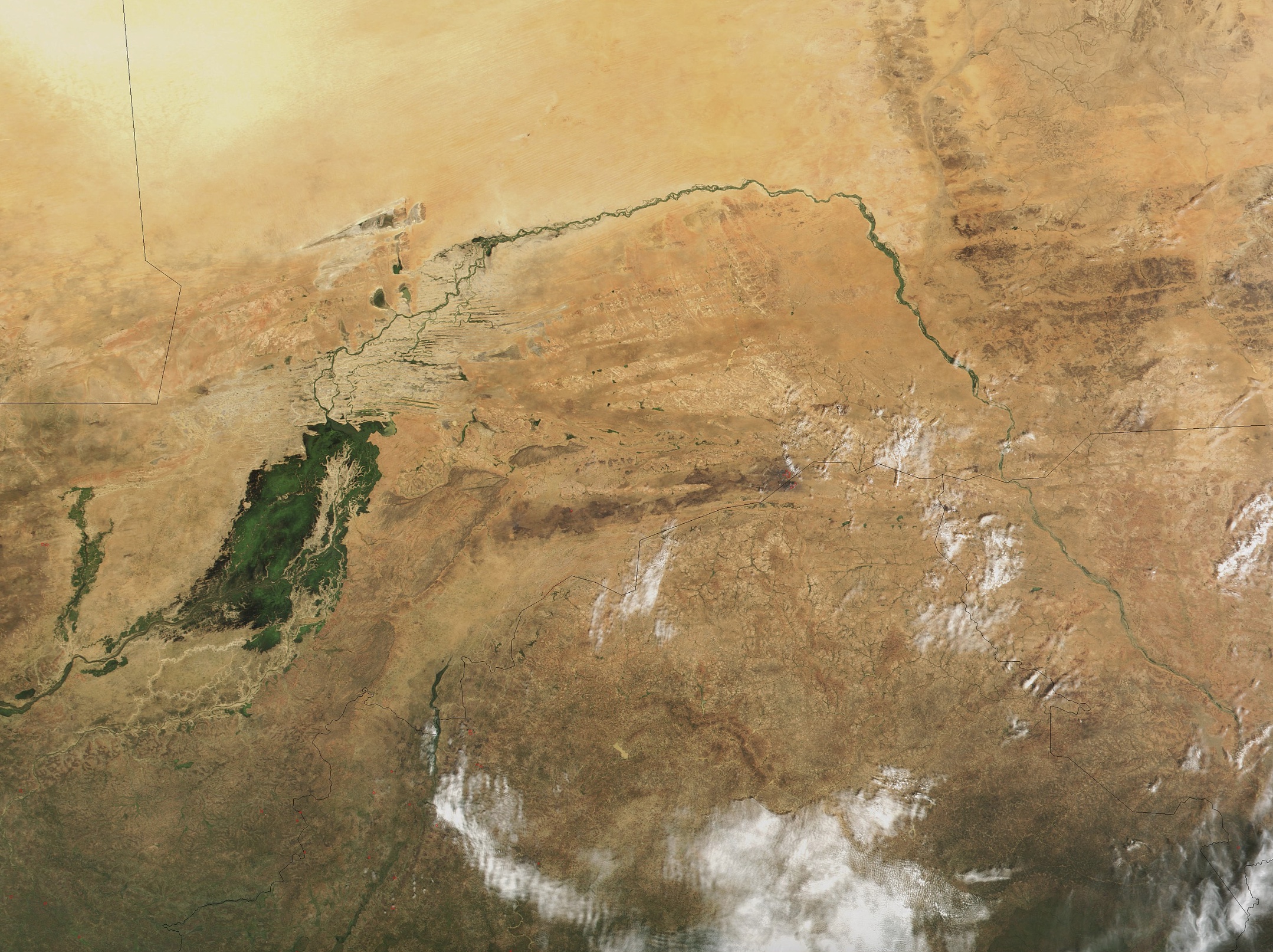 The great bend of the Niger River, seen from space, creates a green arc through the brown of the Sahel and Savanna. The green mass on the left is the Inner Niger Delta, and on the far left are tributaries of the Senegal River. Photo – Jacques Descloitres, MODIS Land Rapid Response Team, NASA/GSFC