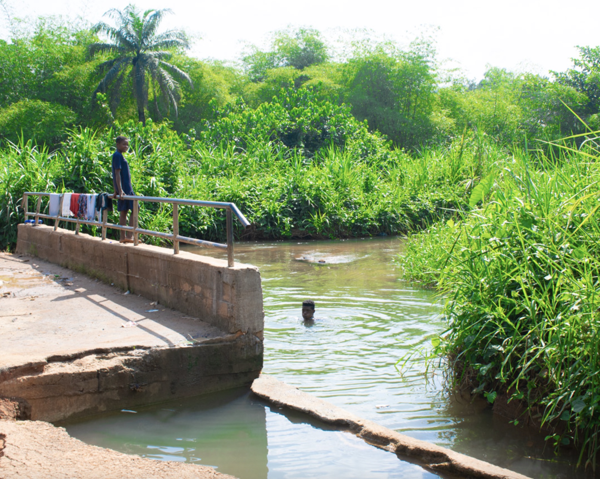 People swimming and washing clothes at the Orashi River. Photo – Dolphyb