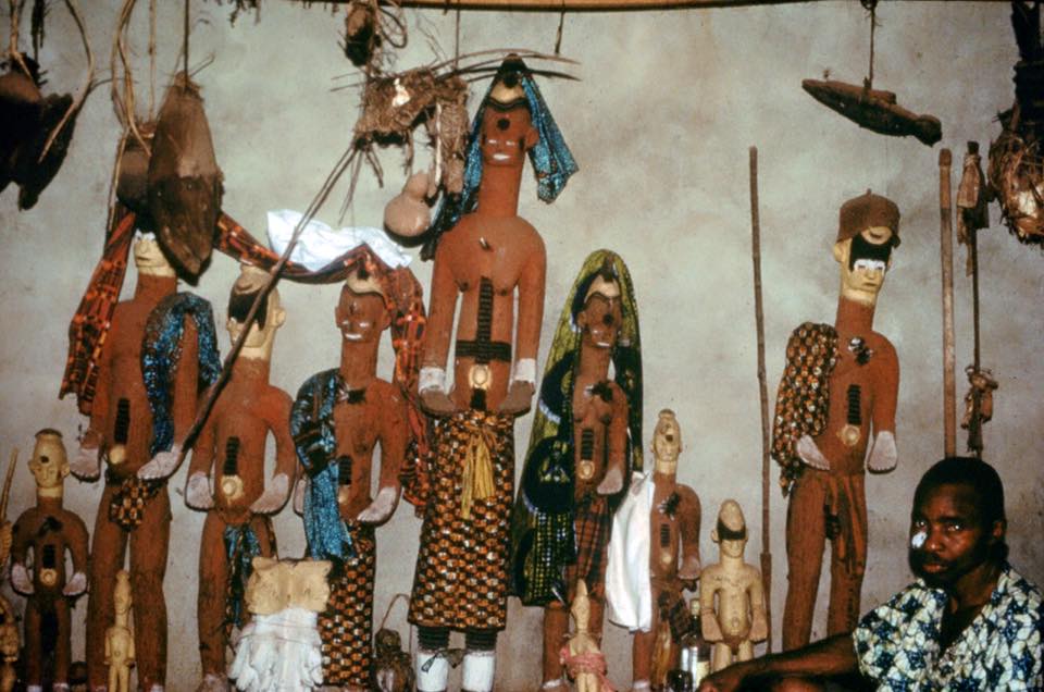 Community shrine to the deities Udo and Ogwugwu (with the shrine's priest), Oba Uke, 1983. Photo by Herbert M. Cole.