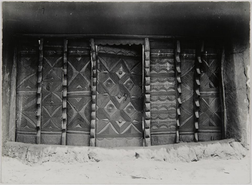 Archival photo of compound entrance with traditional Igbo architecture