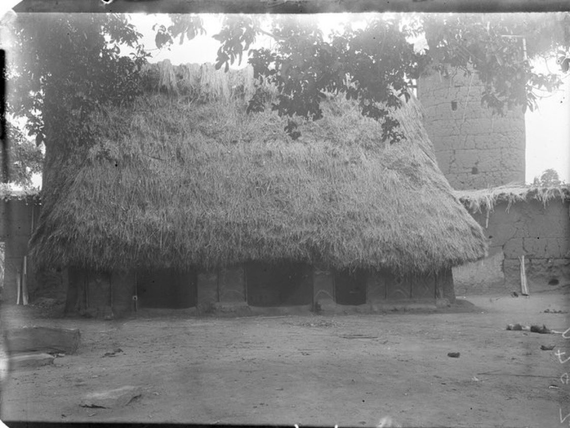 Black-and-white photo of Igbo house and tower structure
