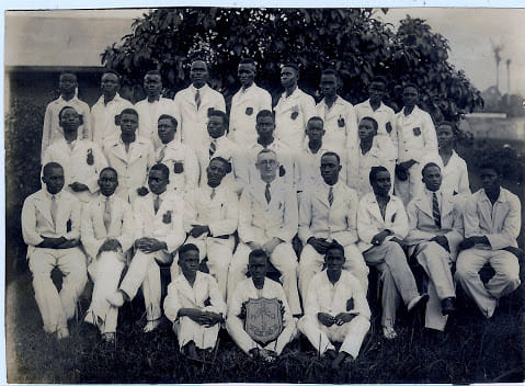Dennis Memorial Grammar School (DMGS), Class of 1932. Seated at the centre of the front row is the fair-complexioned Rev. C. A. Foster, who served as principal of DMGS from 1932 to 1937. That same year marked the departure of his predecessor, Rev. J. D. Jones, who had led the school from 1927 to 1932. Also pictured are several members of the DMGS staff in 1932. Credit: DOBA Secretariat