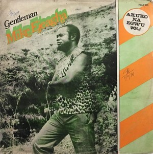 Album cover of Gentleman Mike Ejeagha standing in a natural outdoor setting, wearing a patterned sleeveless top, beside the text “Akuko Na Egwu Vol. 1.”