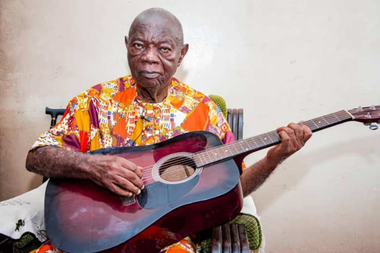 Mike Ejeagha performing with a guitar.